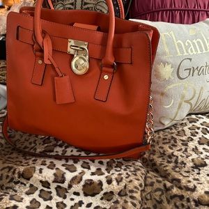 Orange satchel with gold trim and button protectors